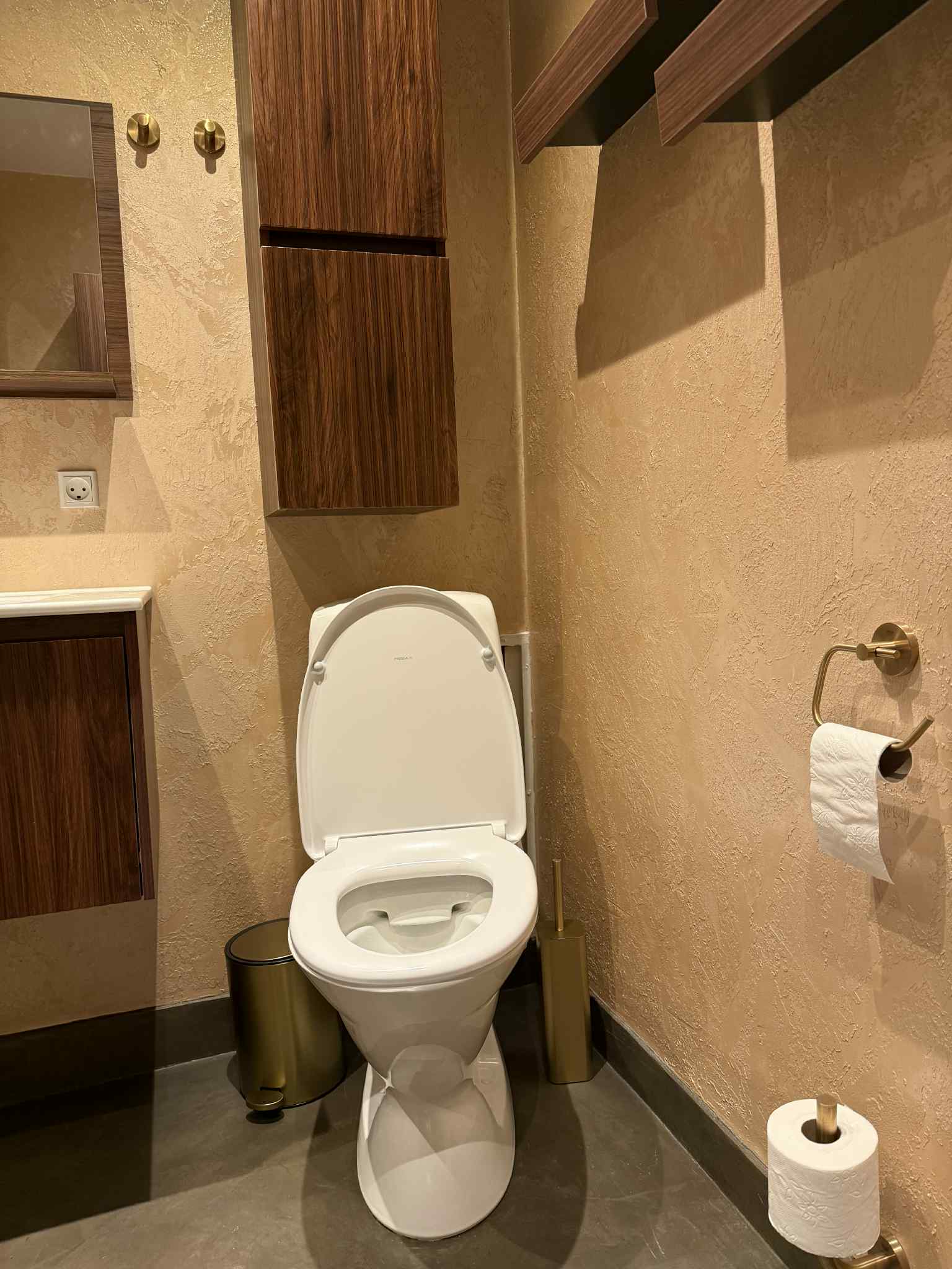 Badeværelse med beige vægge og indbygget træskab