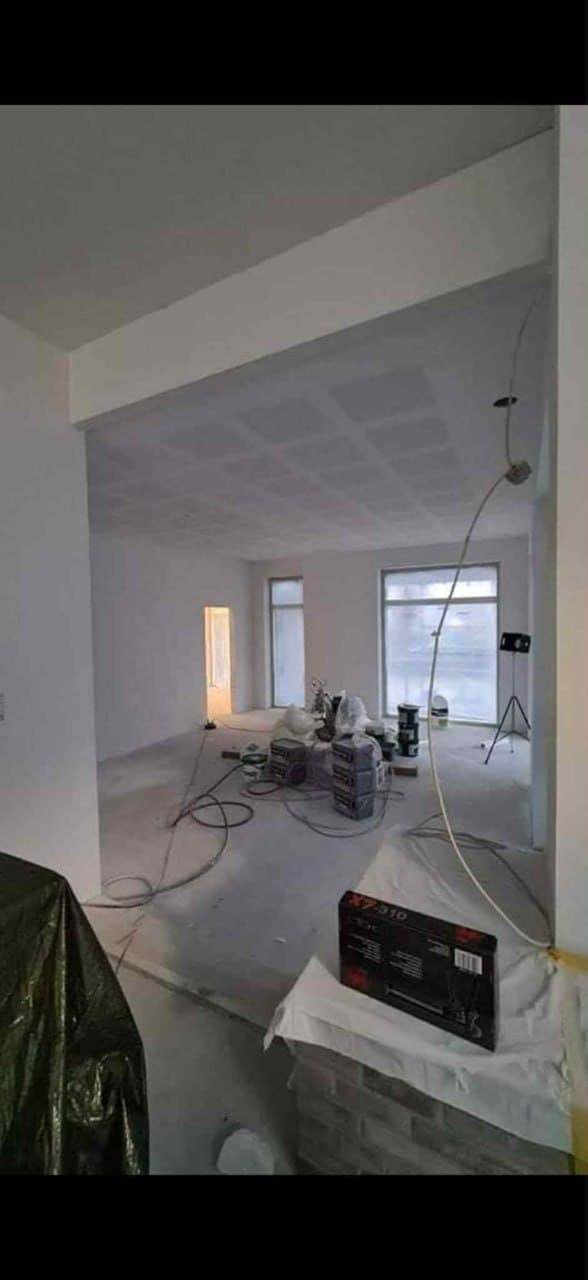 Rum under sprøjtespartling med spartlet loft og byggepladsmaterialer