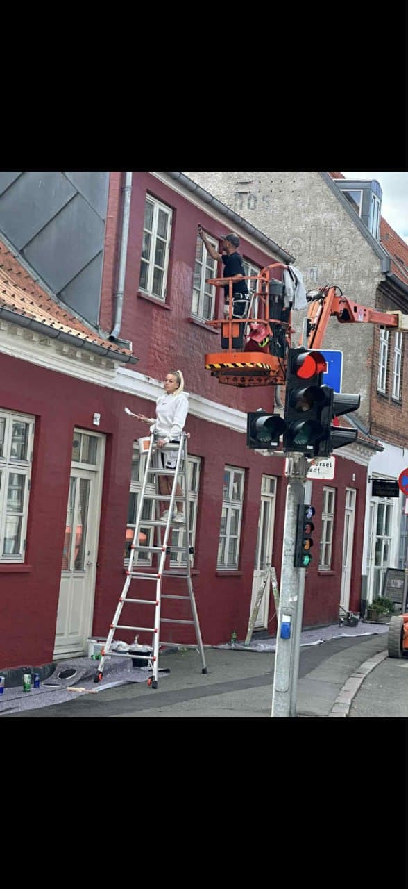 Malere på stige og lift maler rød facade — udvendig maling i Slagelse